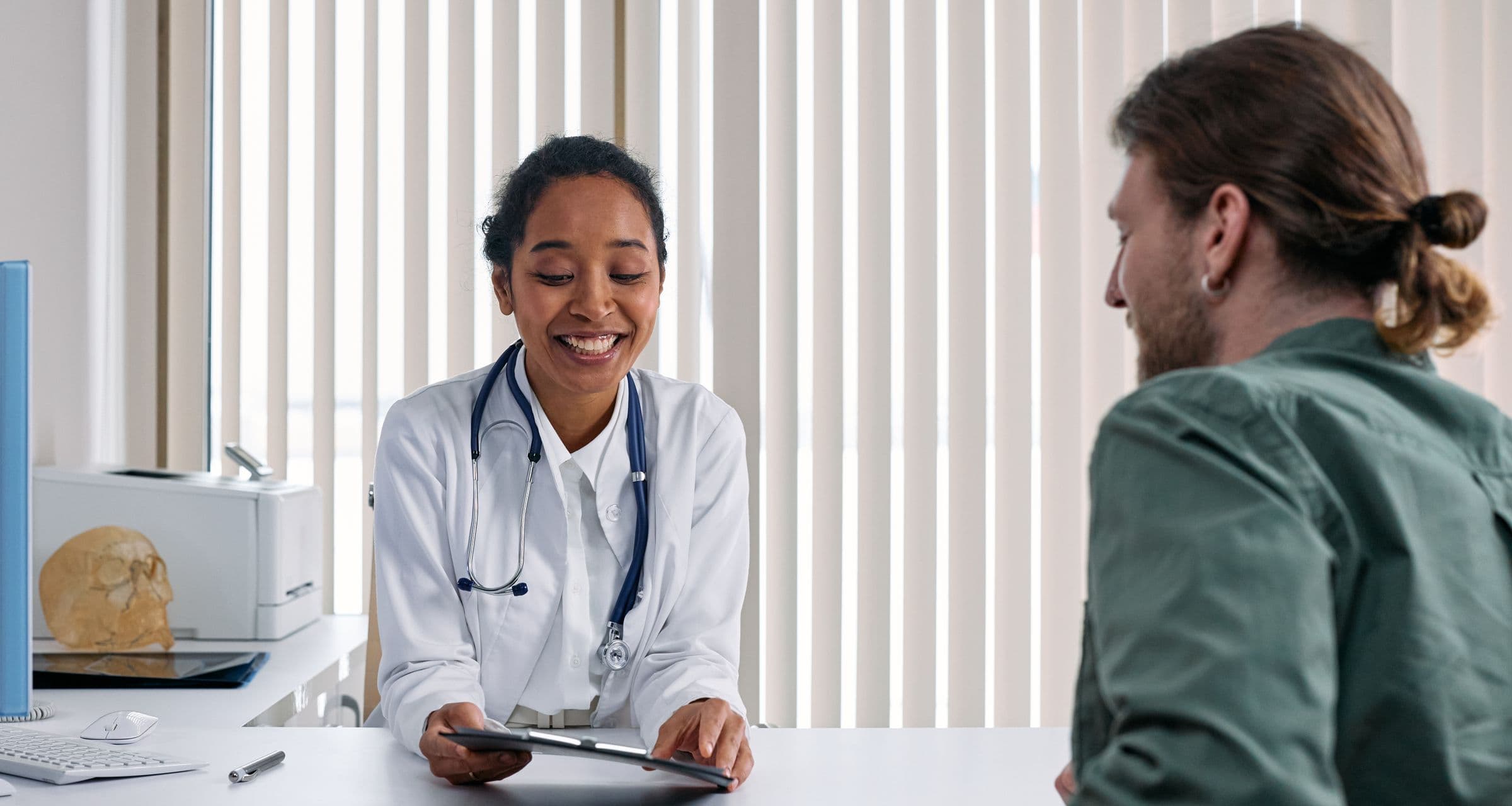 A doctor reviewing a prior-authorization answer with a patient